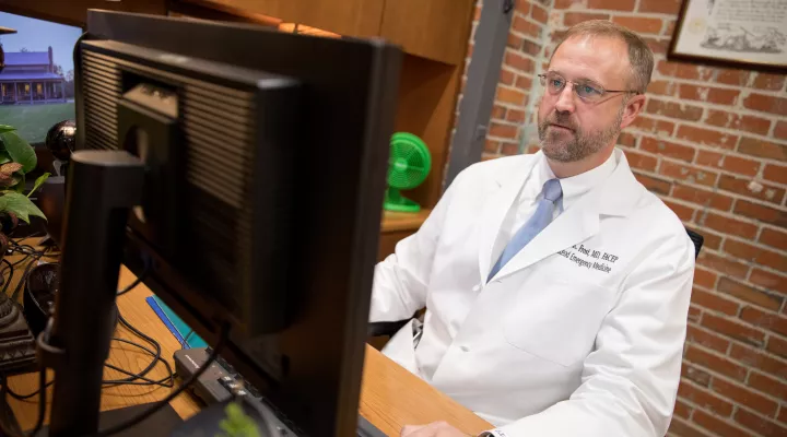 Dr. Bryon Frost, in his Florence office, uses telehealth for virtual appointments with patients.
