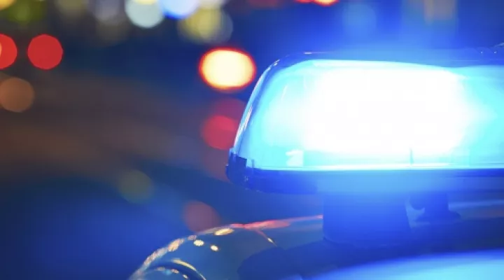 Blue lights on top of a police car, blurred taillights in background