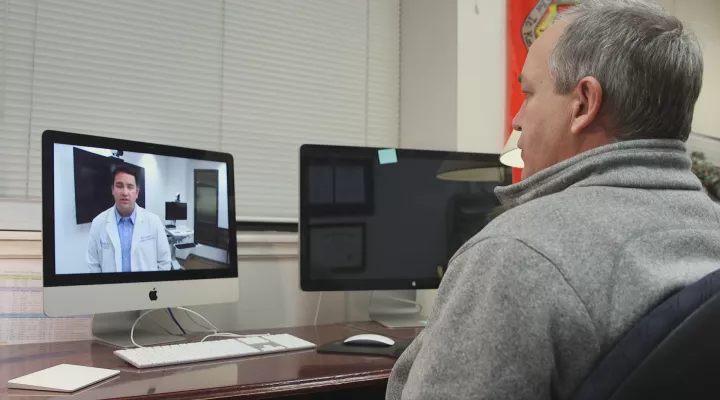 Dr. James Sterrett speaks to pharmacy student Ryan Rosenblatt through telehealth technology.