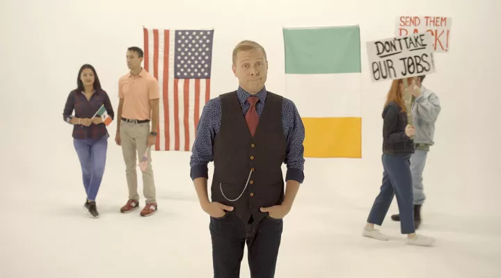 Host Gabe McCauley stands with a group of people in front of American flag