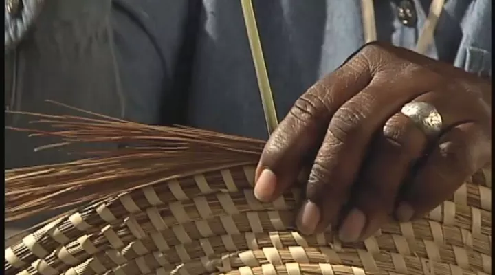 Basketmaker weaving sweetgrass basket