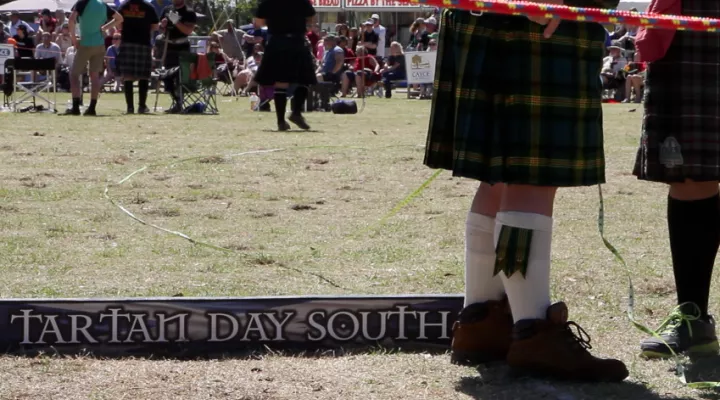 men in kilts with tartan day south sign