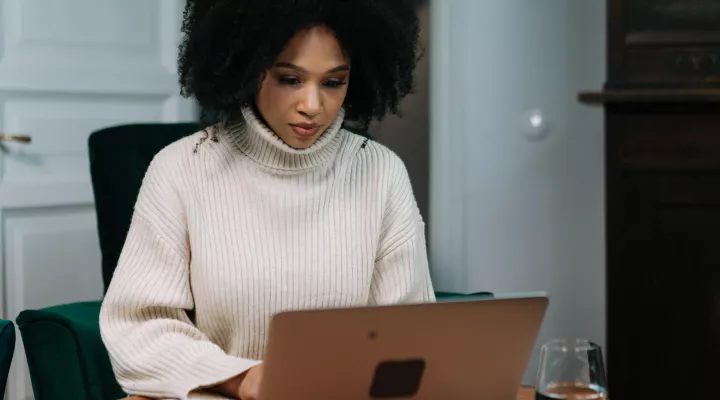woman wearing sweater using laptop