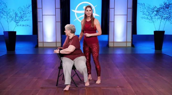 Stacey Millner-Collins with elderly yoga student in chair