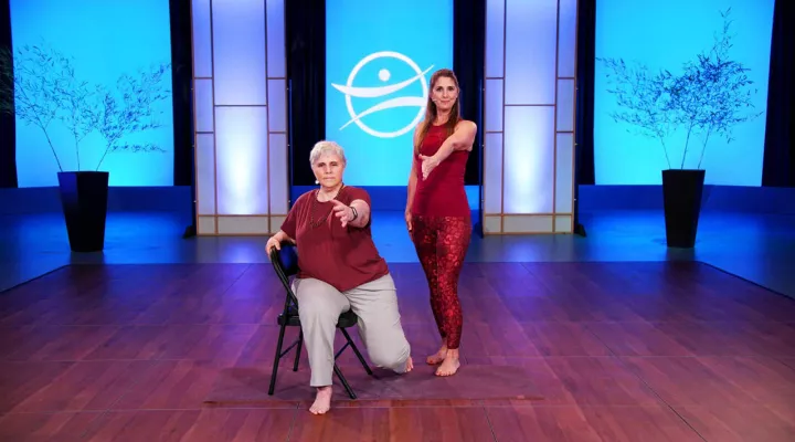 Yoga instructor Stacey Millner-Collins with student doing chair yoga