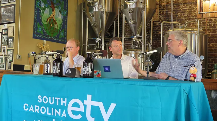 Gavin Jackson speaks with Jeffrey Collins (r) and Jamie Lovegrove (l) in front of a live audience at Rock Hill Brewing Company 