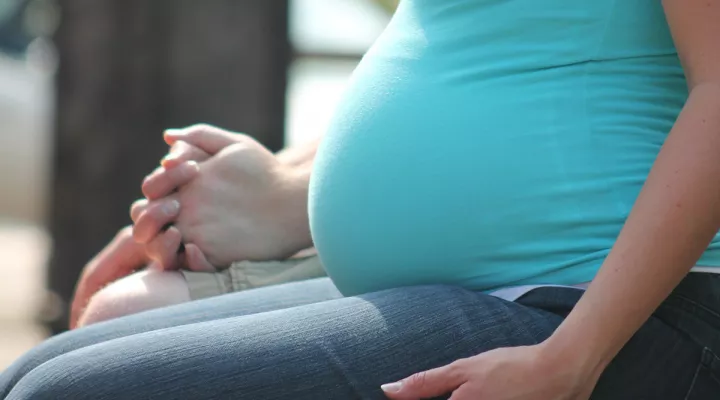 Side view of pregnant woman, sitting.