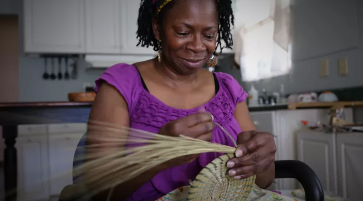 Nakia Wigfall coils a sweetgrass basket at her Mount Pleasant home.
