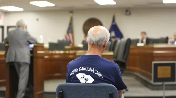 A supporter of a bill to allow people in South Carolina who already have concealed weapons permits to carry their guns in the open listens to a Senate subcommittee hearing on the proposal on Tuesday, April 27, 2021, in Columbia, S.C. The bill doesn't appear to have time to pass this session. (AP Photo/Jeffrey Collins)