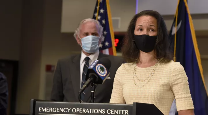 FILE - In this Wednesday, July 29, 2020, file photo, South Carolina state epidemiologist Linda Bell, right, speaks during a COVID-19 briefing, as Gov. Henry McMaster, background left, looks on in West Columbia, S.C. As South Carolina battles an unchecked rise in COVID-19 cases spurred on by the delta variant and dwindling demand for vaccines, on Wednesday, July 28, 2021, state health officials urged people to follow new federal guidance on wearing masks indoors. (AP Photo/Meg Kinnard, File)