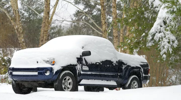 FILE - A pickup truck is covered in snow at the top of a driveway on Southpointe Drive during a winter storm, Sunday, Jan. 16, 2022 in Morganton, N.C. Several vehicles were parked on top of steep driveways due to icing. The Carolinas and Virginia are bracing for more winter weather, which forecasters predict will arrive as mixed precipitation on Thursday, Jan. 20, followed by a round of snow on Friday night into Saturday. 