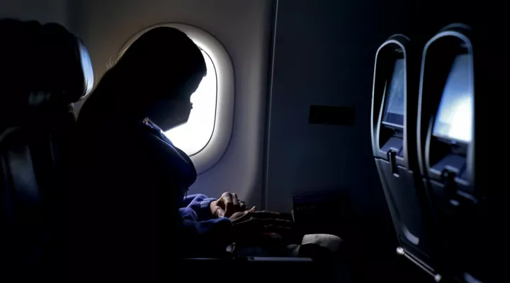 FILE - In this Wednesday, Feb. 3, 2021, file photo, a passenger wears a face mask she travels on a flight from Hartsfield-Jackson International Airport in Atlanta. In a lawsuit filed Tuesday, March 29, 2022, Florida and 20 other states are suing to halt the federal government's pandemic requirement that people wear masks on planes, trains and other public transport. (AP Photo/Charlie Riedel, File)