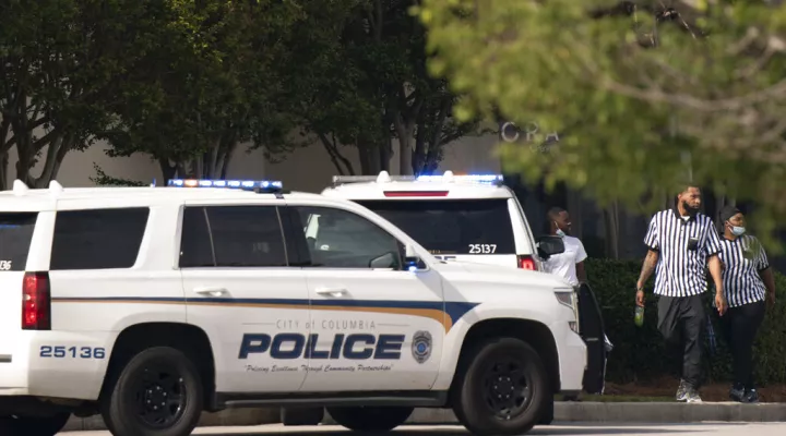 Foot Locker store employees walk near police vehicles outside Columbiana Centre mall in Columbia, S.C., following a shooting, Saturday, April 16, 2022. (AP Photo/Sean Rayford)