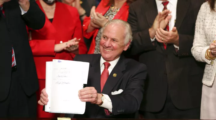 FILE - South Carolina Gov. Henry McMaster holds up a bill banning almost all abortions in the state after he signed it into law on Thursday, Feb. 18, 2021, in Columbia, S.C.  Appellate arguments over a lawsuit challenging South Carolina’s abortion law have been pushed into the new year. Oral arguments in the case had originally been planned for next month, but the 4th U.S. Circuit Court of Appeals has rescheduled them for the last week in January 2022, according to an order from the court. (AP Photo/Jeffre…