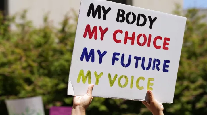 FILE - A woman supporting abortion-rights holds a sign outside the South Carolina Statehouse on July 7, 2022, in Columbia, S.C.  Some South Carolina lawmakers who oppose abortion are being cautious when it comes to tightening the state's already restrictive laws even further. The U.S. Supreme Court overturned Roe v. Wade in June, paving the way for states to enact total bans if they choose to do so. (AP Photo/Meg Kinnard, File)