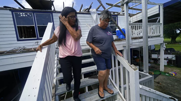 FILE - Louise Billiot, left, a member of the United Houma Nation Indian tribe, walks around the home of her friend and tribal member Irene Verdin, which was heavily damaged from Hurricane Ida nine months before, along Bayou Pointe-au-Chien, in Pointe-aux-Chenes, La., on May 26, 2022. The Federal Emergency Management Agency has developed a singular plan to engage more fully with hundreds of Native American tribes who continue to face climate change-related disasters, the agency announced Thursday, Aug. 18. …