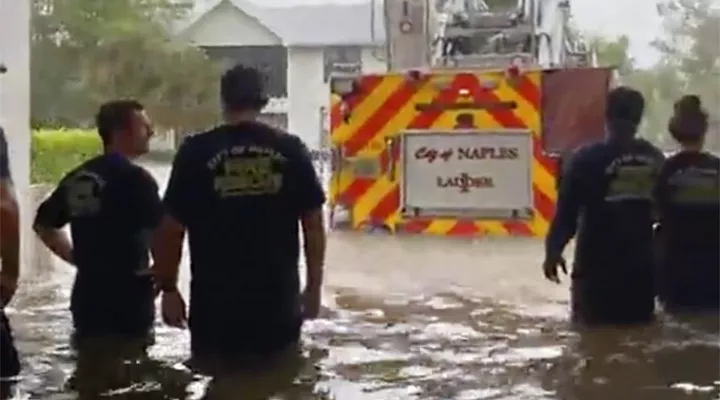 This image provided by the Naples Fire Rescue Department shows firefighters looking out at the firetruck that stands in water from the storm surge from Hurricane Ian on Wednesday, Sept. 28, 2022 in Naples, Fla.  Hurricane Ian has made landfall in southwestern Florida as a massive Category 4 storm.  (Naples Fire Department via AP)