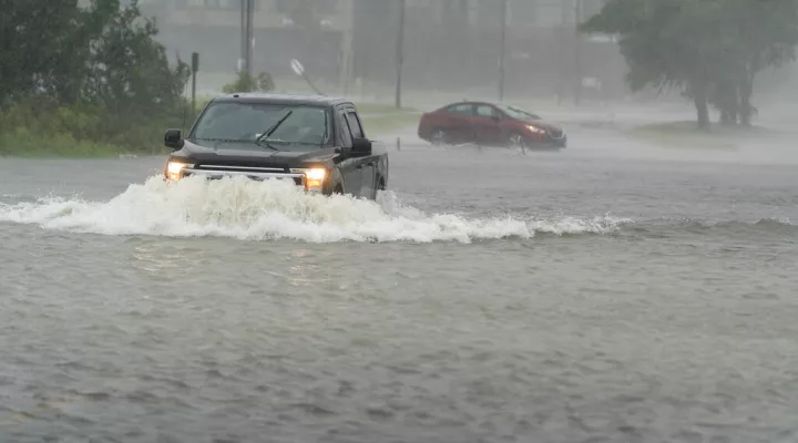 A motorist drives though high water, as another turns around during the effects from Hurricane Ian, Friday, Sept. 30, 2022, in Charleston, S.C. (AP Photo/Alex Brandon)