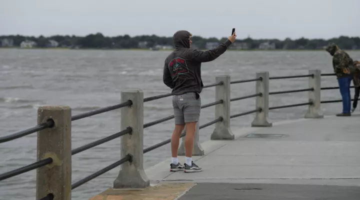 A man takes a selfie in front of white-capped waves in Charleston Harbor as winds from Hurricane Ian begin to roll in to the Charleston, S.C., area on Thursday, Sept. 29, 2022. (AP Photo/Meg Kinnard)