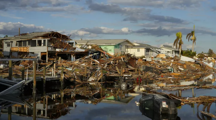 FILE - Cars and debris from washed away homes line a canal in Fort Myers Beach, Fla., Oct. 5, 2022, one week after the passage of Hurricane Ian.  (AP Photo/Rebecca Blackwell, File)