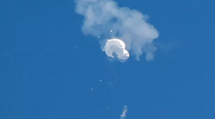 The suspected Chinese spy balloon drifts to the ocean after being shot down off the coast in Surfside Beach, S.C., on Saturday.