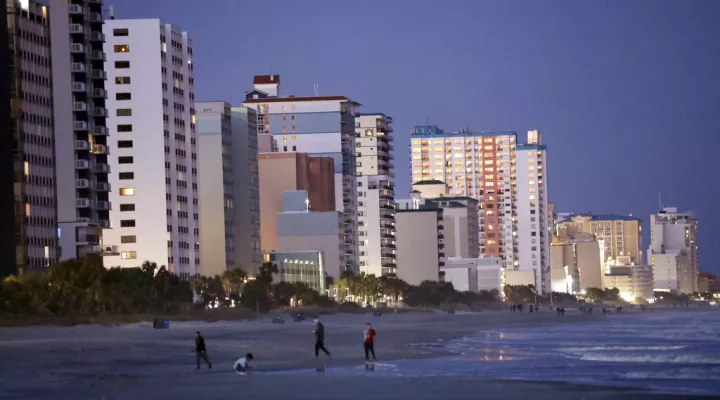 People walk on the beach Saturday, Feb. 4, 2023, in Myrtle Beach, S.C. Earlier in the day, a Chinese balloon was shot down in the area. (AP Photo/Chris Seward)