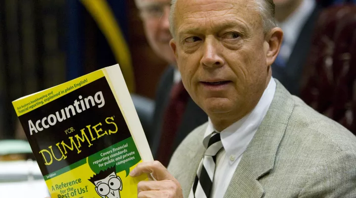 South Carolina Comptroller General Richard Eckstrom holds up a book he wanted to present to his new chief of staff during his introduction at a meeting on Aug. 13, 2009, in Columbia, S.C. Pressure is mounting for Eckstrom after a $3.5 billion accounting error.