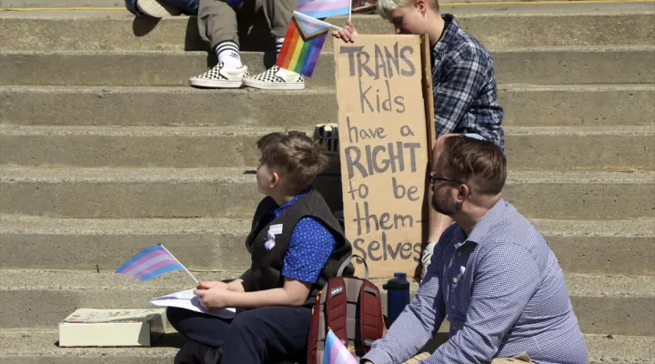 Niko Dittrich-Reed, left, and his father, Dylan Dittrich-Reed, right, attend a rally outside the South Carolina State House, Wednesday, March 29, 2023 in Columbia, S.C. A Senate subcommittee on Wednesday advanced a ban on gender-affirming medical care for minors. (AP Photo/James Pollard)