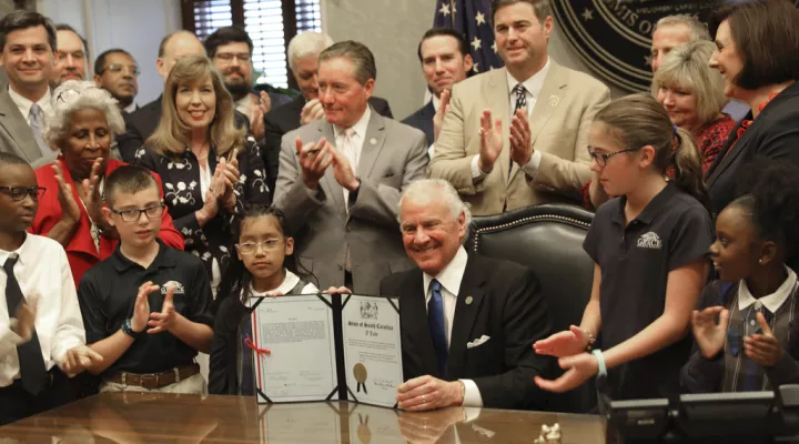 South Carolina Gov. Henry McMaster shows his signature on a bill that will allow parents to spend public money on private schools as part of a small-scale pilot program on Thursday, May 4, 2023, in Columbia, S.C. (AP Photo/Jeffrey Collins)