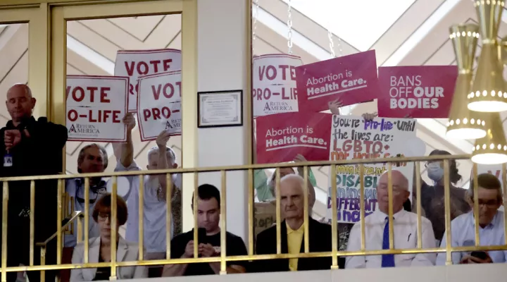 Protesters on both sides of the issue hold signs as North Carolina House members debate, Tuesday, May 16, 2023, in Raleigh, N.C., on whether to override Democratic Gov. Roy Cooper's veto of a bill that would change the state's ban on nearly all abortions from those after 20 weeks of pregnancy to those after 12 weeks of pregnancy. Both the Senate and House had to complete successful override votes for the measure to be enacted into law. The Senate voted to override the veto earlier and the House also voted …