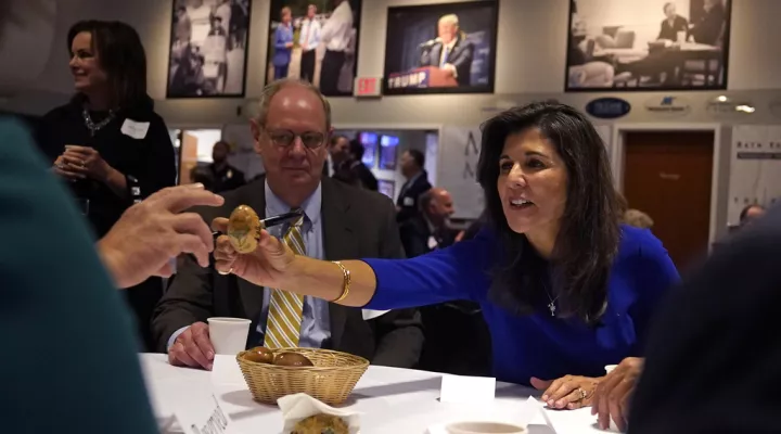 Republican presidential candidate Nikki Haley passes an autographed wooden egg to a guest during a breakfast gathering at Saint Anselm College, Wednesday, May 24, 2023, in Manchester, N.H. (AP Photo/Charles Krupa)