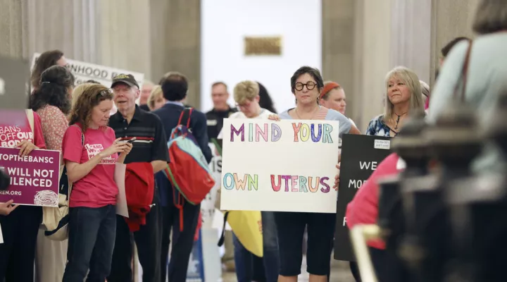 Protesters against a stricter ban on abortion in South Carolina stand in the Statehouse lobby on Tuesday, May, 23, 2023, in Columbia, South Carolina. (AP Photo/Jeffrey Collins)