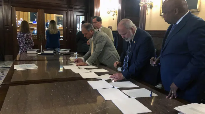  Members of a joint House-Senate Conference Committee sign the final report for a Bond Reform Bill at the Statehouse June 14, 2023.