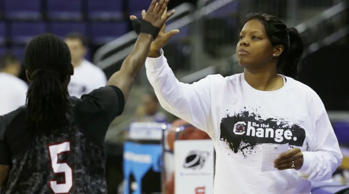 FILE - South Carolina assistant coach Nikki McCray high-fives South Carolina guard Khadijah Sessions (5) during practice at the NCAA women's college basketball tournament, Saturday, March 22, 2014, in Seattle. Two-time Olympic gold medalist and former ABL MVP Nikki McCray-Penson has died. She was 51. McCray-Penson was an assistant women's basketball coach at Rutgers last season and the school confirmed her death, although the cause of her passing was not immediately known.   (AP Photo/Ted S. Warren, File)