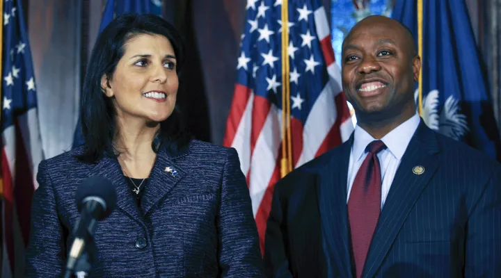 FILE - South Carolina Gov. Nikki Haley, left, announces Rep. Tim Scott, right, as Sen. Jim DeMint's replacement in the U.S. Senate during a news conference at the South Carolina Statehouse, Dec. 17, 2012, in Columbia, S.C.  In 2015, Nikki Haley and Tim Scott attended the funerals of those slain by a racist gunman at Mother Emanuel AME Church. Scott would later tear up on the Senate floor recounting the faith of the fallen and their families. Haley would go on to write that she leaned on God and her faith d…