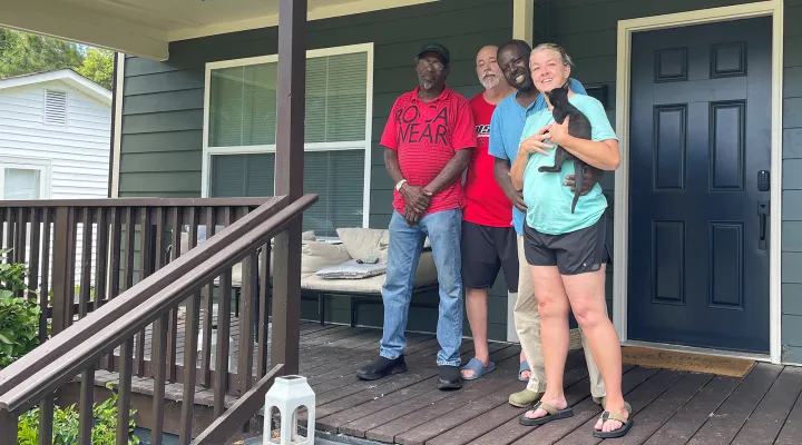 L-R: Thomas Cunningham, Roger Boone, Gerald Adams, and Scarlett Adams and their unofficial mascot, a cat they found living on their porch shortly before this photo was taken. These residents all lived on the streets until they entered Rock Hill's Rapid Rehousing Program.