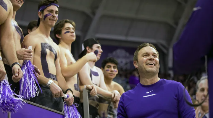 TCU athletic director Jeremiah Donati celebrates with fans before an NCAA college basketball game between TCU and Texas in Fort Worth, Texas, Tuesday, Jan. 25, 2022. (AP Photo/Gareth Patterson)