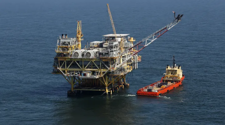 FILE - This April 10, 2011, file photo, shows a rig and supply vessel in the Gulf of Mexico, off the coast of Louisiana. The Biden administration on Friday proposed up to three oil and gas lease sales in the Gulf of Mexico over the next five years — and none in Alaska — as it tries to navigate between energy companies that have pressed for greater oil and gas production and environmental activists who have urged President Joe Biden to shut down new offshore drilling in the fight against climate change.