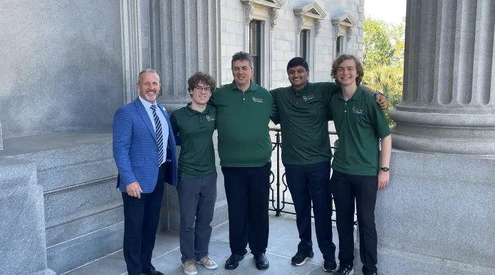 River Bluff High School math and robotics instructor Horst Daichendt (center) joined by Rep. Chris Wooten (left), along with students Robert Albetel (second from left), Dharm Patel (fourth from left), and Brady Miller (right).