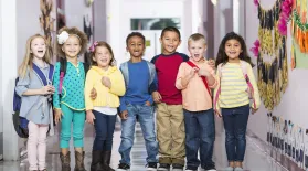 photo of several early-ed students standing with backpacks on in a school hallway