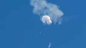 The suspected Chinese spy balloon drifts to the ocean after being shot down off the coast in Surfside Beach, S.C., on Saturday.